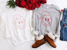 "**PLEASE READ FULL DESCRIPTION** Smiley Face Santa Hat TShirts & Sweatshirts! Made To Order - TSHIRT - Comfort Colors brand (unisex sizing) - Short Sleeve - 100% Ring spun Cotton, Pre-Shrunk - Super Comfortable Wash after Wash! - For an oversized fit, I recommend sizing up one. - SWEATSHIRT - Gildan Heavy Blend Crewneck - Long Sleeve - 8.0 oz., 50/50 pre-shrunk cotton/polyester - Fleece lined - super cozy + soft! - Unisex sizing - Processing takes up to 6 days. We offer RUSH ORDER SERVICE f Smiley Face Christmas, Santa Tshirt, Mickey Sweatshirt, Smiley Face Shirt, Mickey Shirt, Santa Shirt, Santa Shirts, Hoodie Brands, Disney Tees