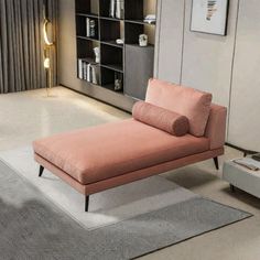 a pink chaise lounger sitting on top of a rug in a living room