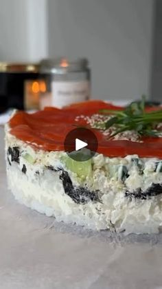 a close up of a cake with tomatoes and cream cheese on the top, sitting on a table