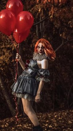 a woman with red hair holding two red balloons