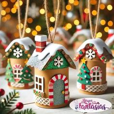 three small gingerbread houses decorated with candy canes and snowflakes are sitting on a table in front of a christmas tree