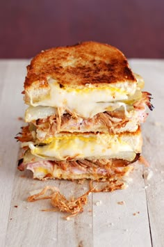 a grilled cheese sandwich is stacked high on top of each other with meat and vegetables