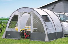 a van is parked next to a tent on the grass