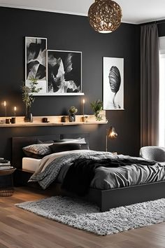 a black and white bedroom with candles on the nightstands, pictures above the bed