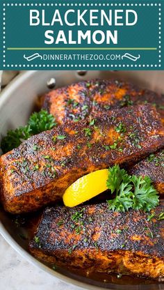 blackened salmon in a pan with lemon wedges and parsley