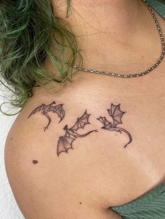 a woman with a tattoo on her chest that has bats flying out of the back