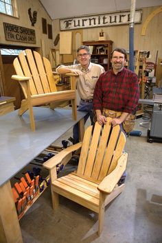 two men standing next to each other in a room filled with wooden furniture and tools