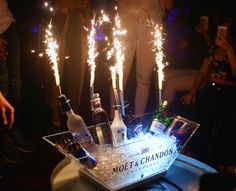 some bottles and sparklers in a basket on a table