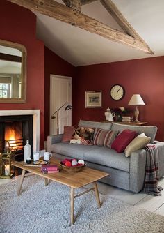 a living room filled with furniture and a fire place next to a mirror on the wall