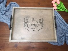 a wooden tray with the words'the gentle family'on it next to tulips