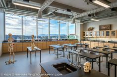 an empty classroom with desks and skeleton sculptures