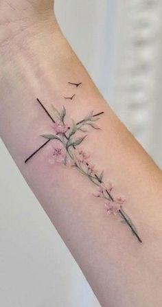 a woman's arm with a cross and flowers on it