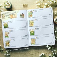 an open planner with stamps on it next to flowers