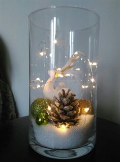 a glass vase filled with snow and lights