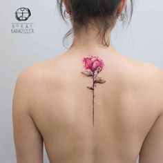 a woman's back with a flower tattoo on it