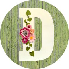 the letter d is decorated with flowers and leaves