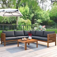 a couch and table on a deck with an umbrella