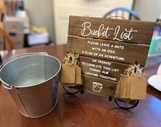 a bucket and sign sitting on top of a wooden table