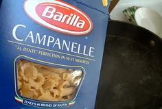 a box of campanelle pasta sitting on top of a stove next to a frying pan