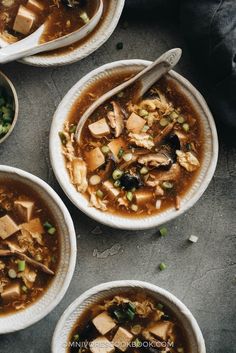 three bowls of soup with tofu and peas