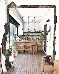 an open kitchen and dining area with wooden floors, white walls, and large windows