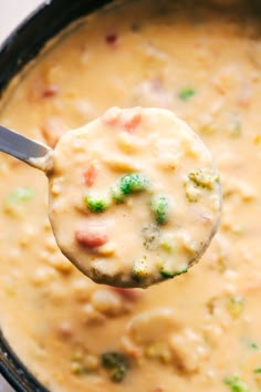 a spoon full of soup with broccoli and cheese