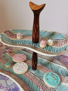 three tiered trays with decorated cookies and pastries on them in the shape of waves