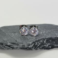 Add two or more items to your cart and enter the code: MOREMETAL during checkout for 15% off of your whole order! This beautiful stud earring set is made from two stunning 6mm round cut white cubic zirconia gemstones. The gemstones are set into a 304 stainless steel 6 prong post, and come with a stainless steel back.   A complimentary polishing cloth will be included with your order so you can keep your jewelry looking brand new. Classic Studs For Gift, Classic Hypoallergenic Crystal Earrings For Anniversary, Silver Crystal Earrings Gift Round Cut, Sterling Silver Crystal Earrings With Round Cut, Classic Hypoallergenic Crystal Earrings As Gift, Polished Cubic Zirconia Jewelry, Round Cut, White Round Cut Sterling Silver Diamond Earrings, Diamond White Round Cut Sterling Silver Crystal Earrings, Bronze Bangle