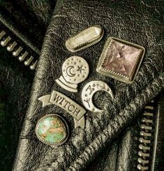 a black leather jacket with buttons and other things on the back pocket that are attached to it