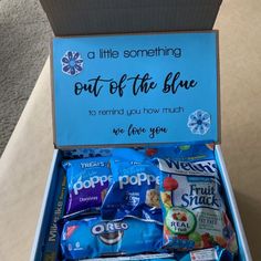 a blue box filled with snacks sitting on top of a table