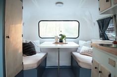 the inside of a camper with two seats and a table