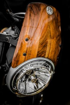 the front end of a motorcycle with a wooden headlight