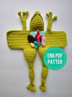 a crocheted frog with candy on it's chest and arms in the shape of a cross