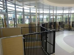 a spiral staircase in an office building with lots of glass walls and doors on both sides