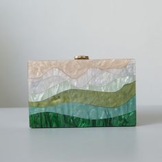 Looking for a unique and stylish piece with a designer touch? You'll love this beautiful Luxury Emerald Striped Acrylic Clutch Bag! With its beautiful pearlescent sheen, this stylish clutch won't go unnoticed. Perfect to dress up an outfit for a party or a wedding. Available with single chain or two chains including a gorgeous green handle, pick your favourite! Style: Eclectic Boho Chic Occasions: Evening, garden party or use as wedding bag Smart features: Hasp closure, cell phone fit, mini hand Acrylic Box Clutch, Cute Mini Bags, Green Clutch, Acrylic Bag, Green Clutches, Trendy Bags, Acrylic Clutch, Clutch Bag Wedding, Green Purse