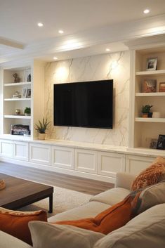 a living room filled with furniture and a flat screen tv mounted on the wall above it