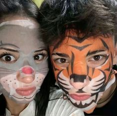 two people with their faces painted like tigers