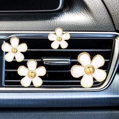 three flowers are attached to the center console of a car's dash board and air vent