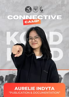 a woman pointing at the camera in front of a sign that says connective camp