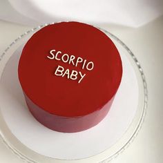 a red cake with the words scorpio baby on it sitting on a plate