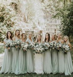 a group of women standing next to each other holding bouquets