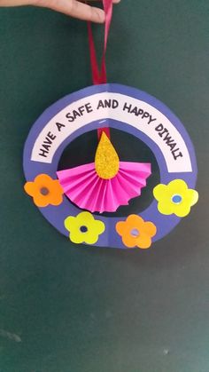 a hand holding a paper decoration with the words have a safe and happy day on it