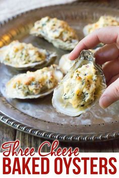 a hand picking up some baked oysters from a plate with text overlay that reads three cheese baked oysters