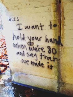 graffiti on the side of a building with writing written in black and white, next to a fire hydrant that reads i want to hold your hand when you were 30 and say that we made it