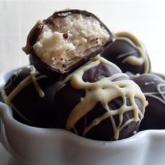 chocolate covered truffles in a white bowl with drizzled icing