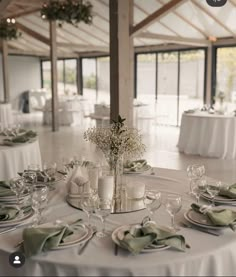 the table is set with white linens and place settings