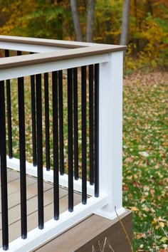 a wooden deck with black railings in the fall