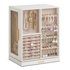 a white jewelry box filled with lots of earrings