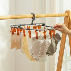 a person is holding several pairs of socks on a rack