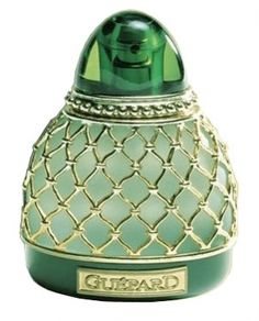 a green glass perfume bottle with an ornate design